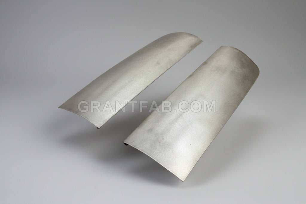 A pair of silver metal front corner fillers for a vehicle.