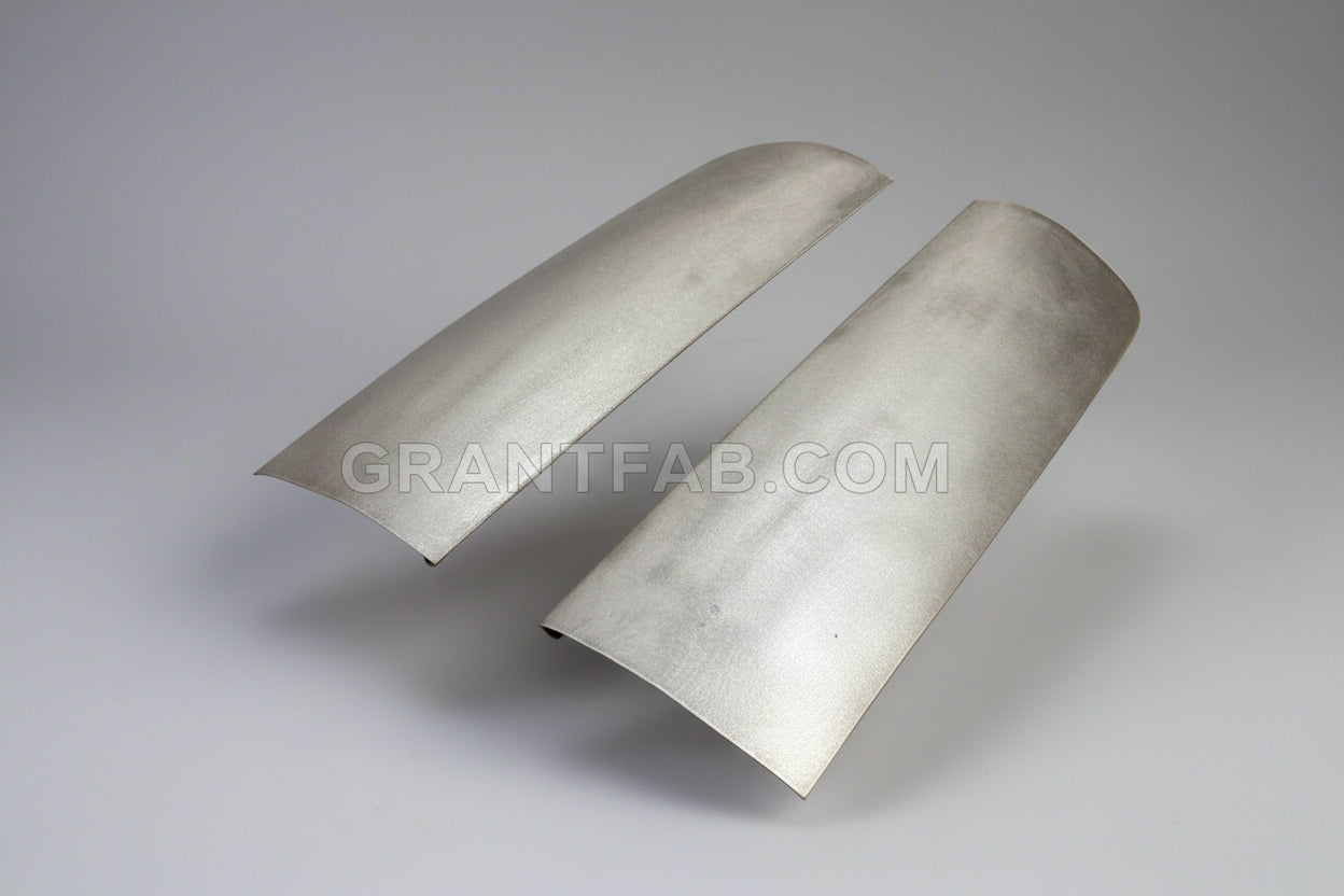 A pair of silver metal front corner fillers for a vehicle.