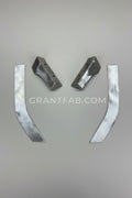 Four machined metal parts, including two angled bracket-like pieces and two curved flat strips, arranged on a brown cardboard background.