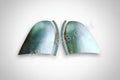 A pair of silver metal corner fillers for a vehicle.
