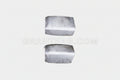 A pair of silver-colored sheet metal corner fillers for a Nissan Hardbody vehicle.