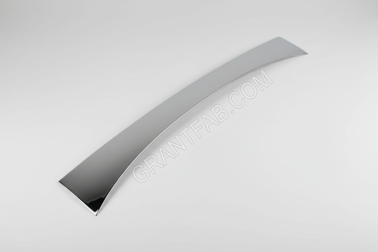 A silver-colored metal wiper cowl filler piece for a Nissan vehicle.