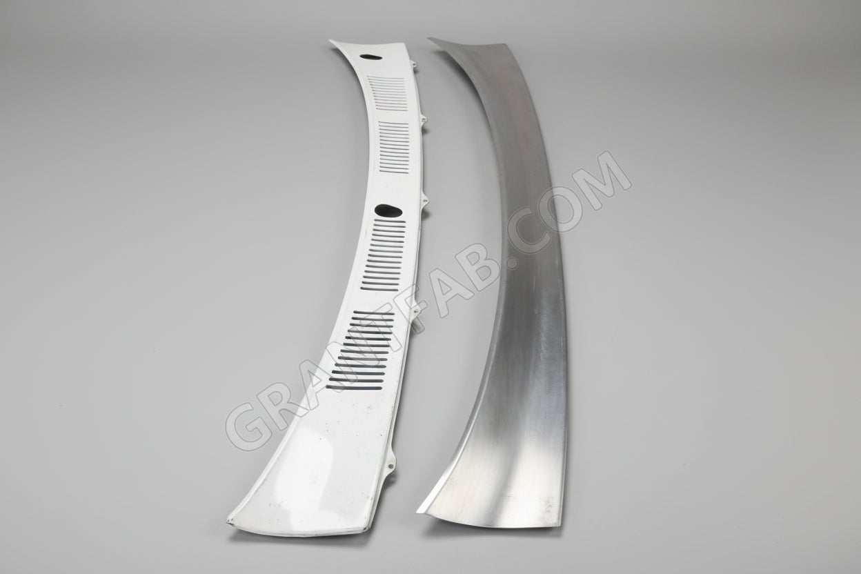 A silver-colored metal wiper cowl filler piece for a Toyota vehicle, displayed against a black background.